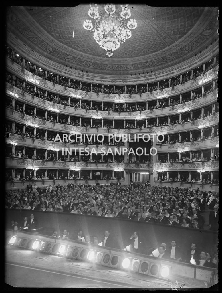 La sala del Teatro alla Scala gremita di pubblico, ripresa dal palcoscenico, in occasione della serata inaugurale della stagione lirica 1954-1955 con l'opera "La Vestale", di Gaspare Spontini, diretta da Antonino Votto, con la regia di Luchino Visconti