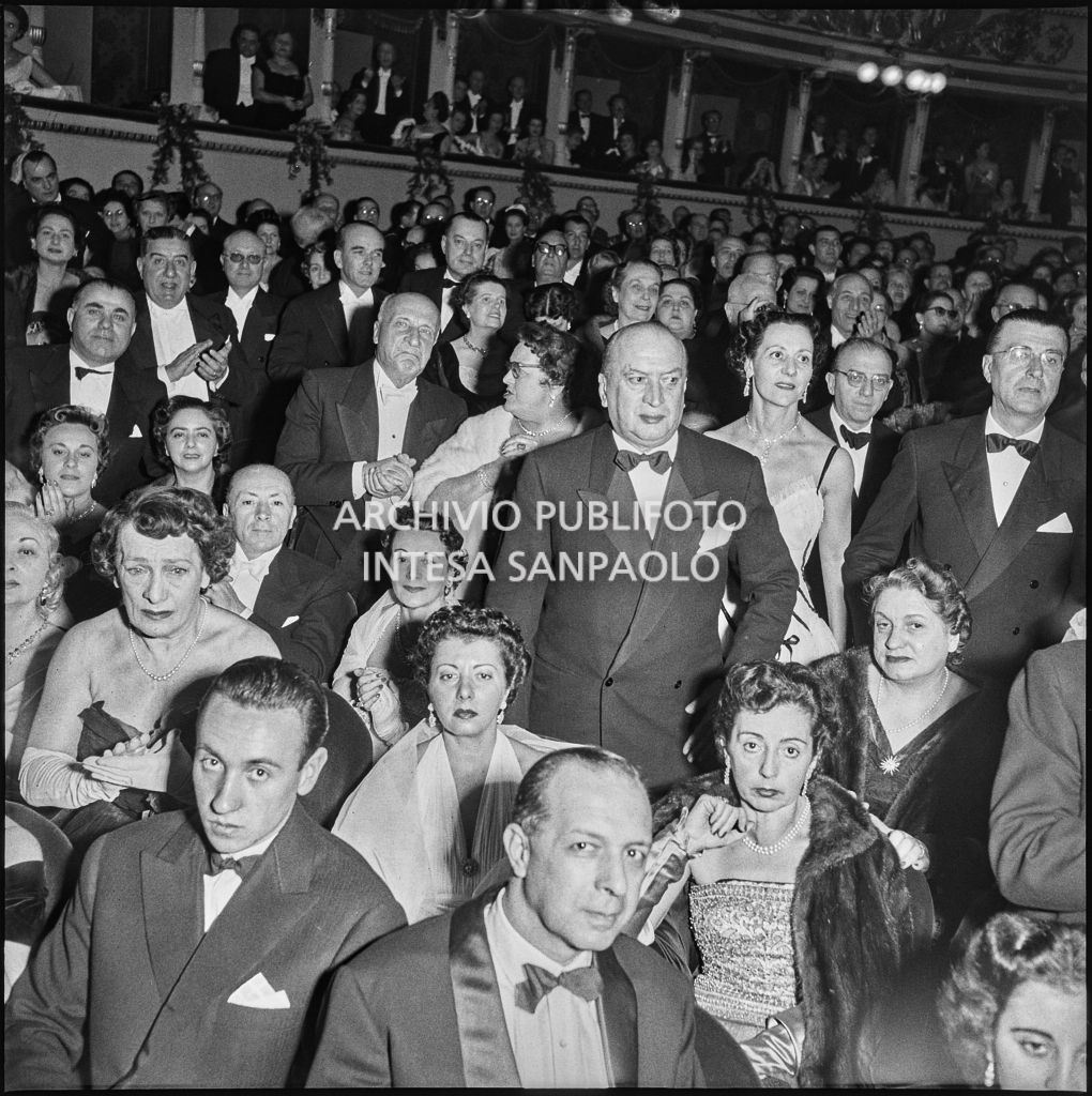 Pubblico in piedi nella platea del Teatro alla Scala in occasione della serata inaugurale della stagione lirica 1954-1955 con l'opera "La Vestale", di Gaspare Spontini, diretta da Antonino Votto, con la regia di Luchino Visconti