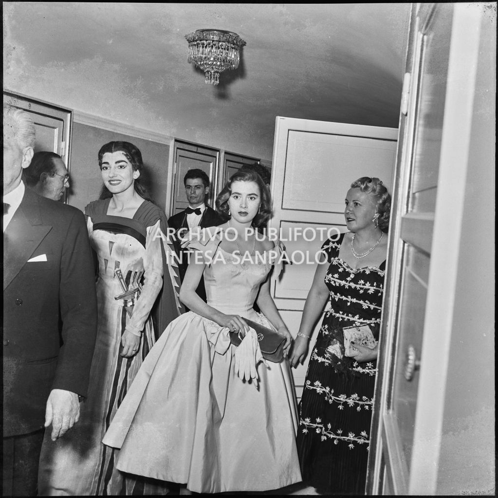 Il sovrintendente al Teatro alla Scala Antonio Ghiringhelli e la soprano Maria Callas, in abiti di scena, tra gli spettatori, al termine della rappresentazione dell'opera "Norma" di Vincenzo Bellini, diretta da Antonino Votto con la regia di Margherita Wallmann, che inaugura la stagione lirica 1955-1956 del Teatro alla Scala