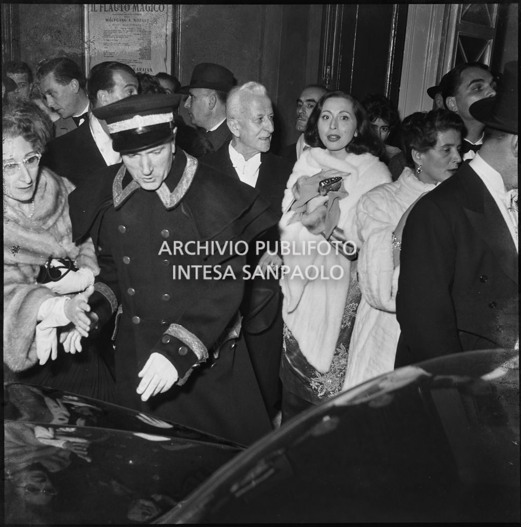 La contessa Cella, nella galleria delle carrozze del Teatro alla Scala, tra la folla di spettatori in attesa delle automobili, al termine della serata inaugurale della stagione lirica 1955-1956 con l'opera "Norma" di Vincenzo Bellini, diretta da Antonino Votto con la regia di Margherita Wallmann