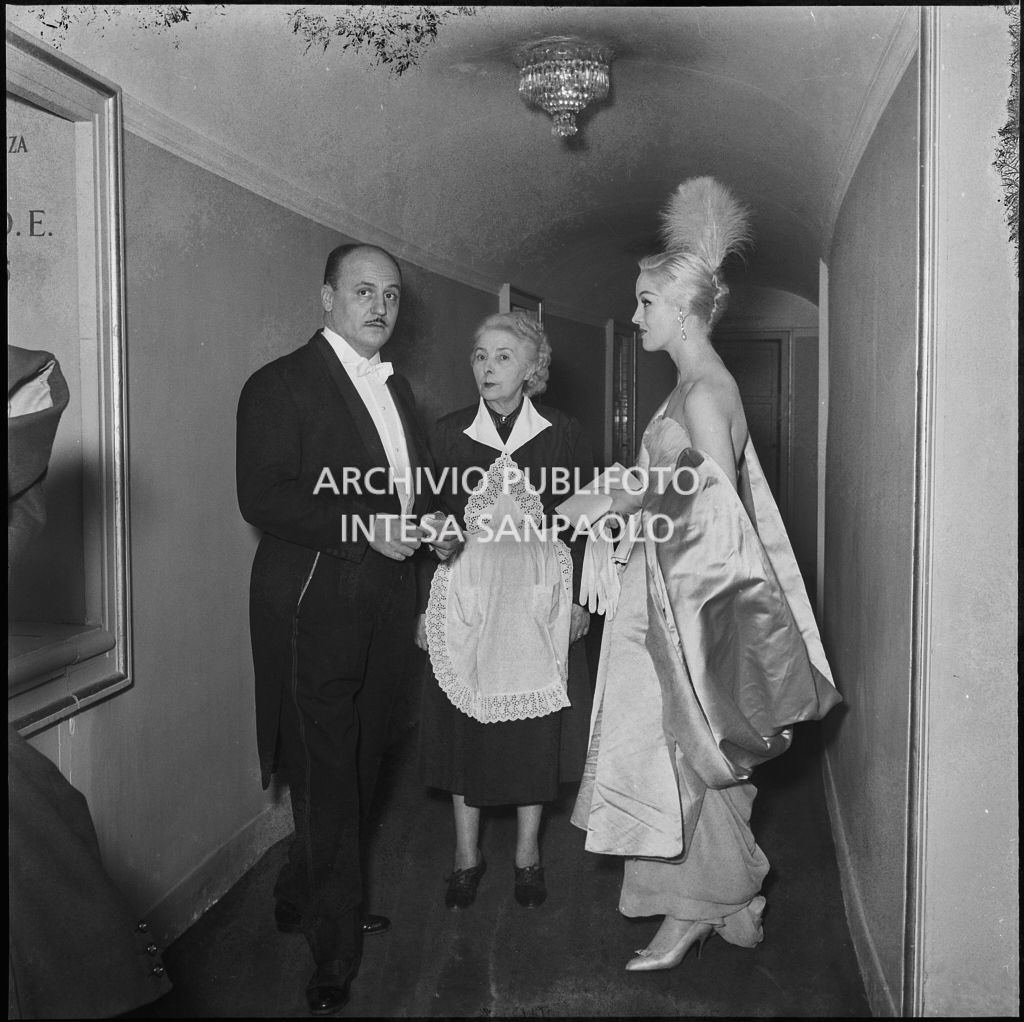 Lo stilista Pierre Balmain e Barbara Balmain al Teatro alla Scala in occasione della serata inaugurale della stagione lirica 1956-1957 con l'opera "Aida" di Giuseppe Verdi, diretta da Antonino Votto con la regia di Franco Enriquez