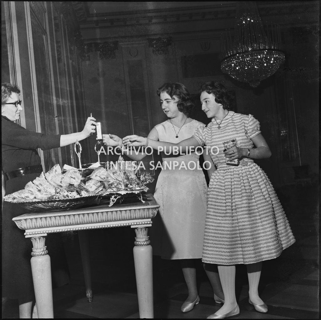 Camilla Maestrelli e Angela Callegari al tavolo dei dolci del Teatro alla Scala in occasione della serata inaugurale della stagione lirica 1956-1957 con l'opera "Aida" di Giuseppe Verdi, diretta da Antonino Votto con la regia di Franco Enriquez