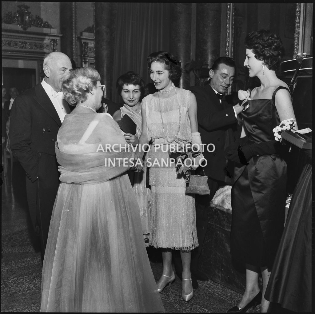 Jole Veneziani stringe la mano alla signora Francesca Ruspoli Blanc al Teatro alla Scala in occasione della serata inaugurale della stagione lirica 1957-1958 con l'opera "Un ballo in maschera", di Giuseppe Verdi, diretta da Gianandrea Gavazzeni e la regia di Margherita Wallmann