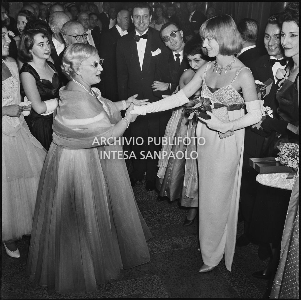 Jole Veneziani stringe la mano a Marisa Quaglia al Teatro alla Scala in occasione della serata inaugurale della stagione lirica 1957-1958 con l'opera "Un ballo in maschera", di Giuseppe Verdi, diretta da Gianandrea Gavazzeni e la regia di Margherita Wallmann