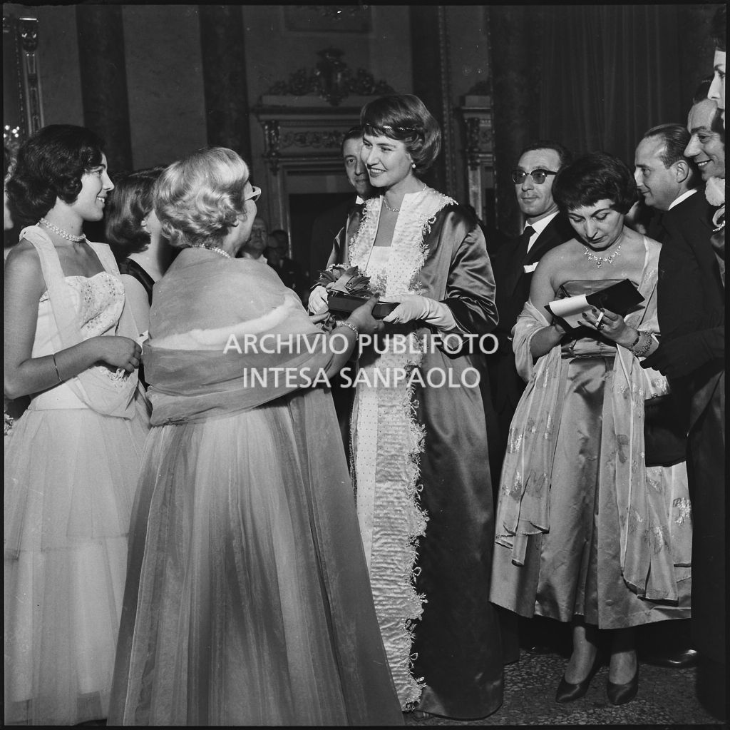 Jole Veneziani consegna un pacchetto a Rita Cook al Teatro alla Scala in occasione della serata inaugurale della stagione lirica 1957-1958 con l'opera "Un ballo in maschera", di Giuseppe Verdi, diretta da Gianandrea Gavazzeni e la regia di Margherita Wallmann