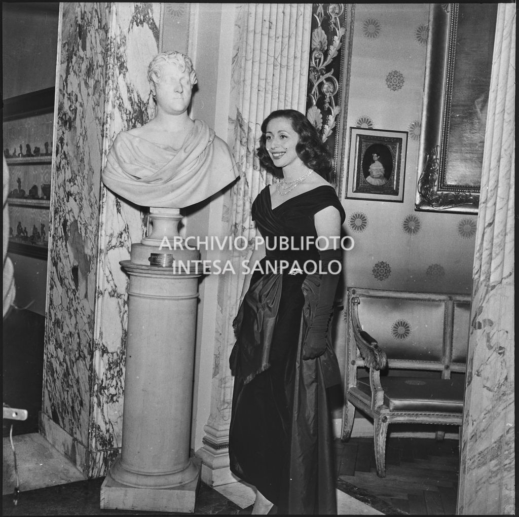 La contessa Cella, moglie del conte Franco Cella di Rivara, in posa nel museo del Teatro alla Scala in occasione della serata inaugurale della stagione lirica 1957-1958 con l'opera "Un ballo in maschera", di Giuseppe Verdi, diretta da Gianandrea Gavazzeni e la regia di Margherita Wallmann