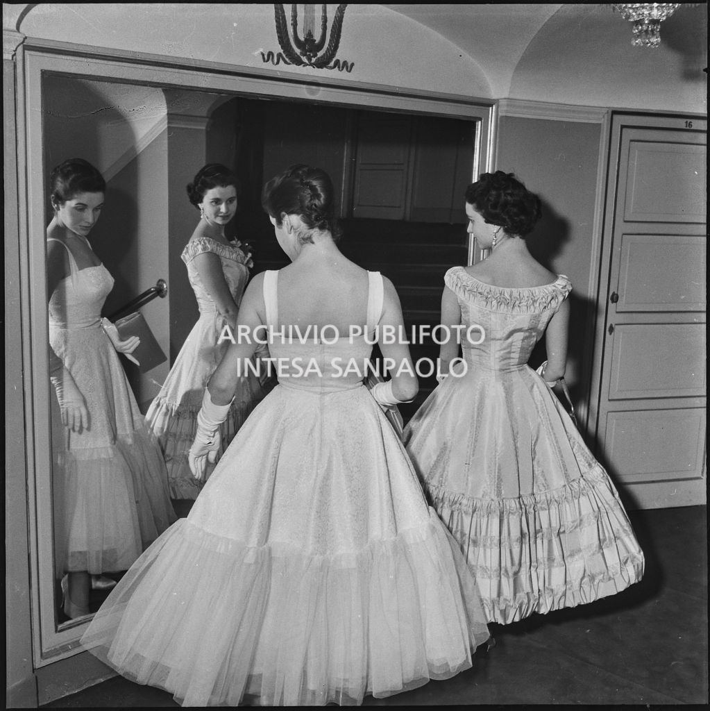 Stellina e Antonia Magri, nipoti del sovrintendente al Teatro alla Scala Antonio Ghiringhelli, in posa davanti ad uno specchio del Teatro alla Scala in occasione della serata inaugurale della stagione lirica 1957-1958 con l'opera "Un ballo in maschera", di Giuseppe Verdi, diretta da Gianandrea Gavazzeni e la regia di Margherita Wallmann