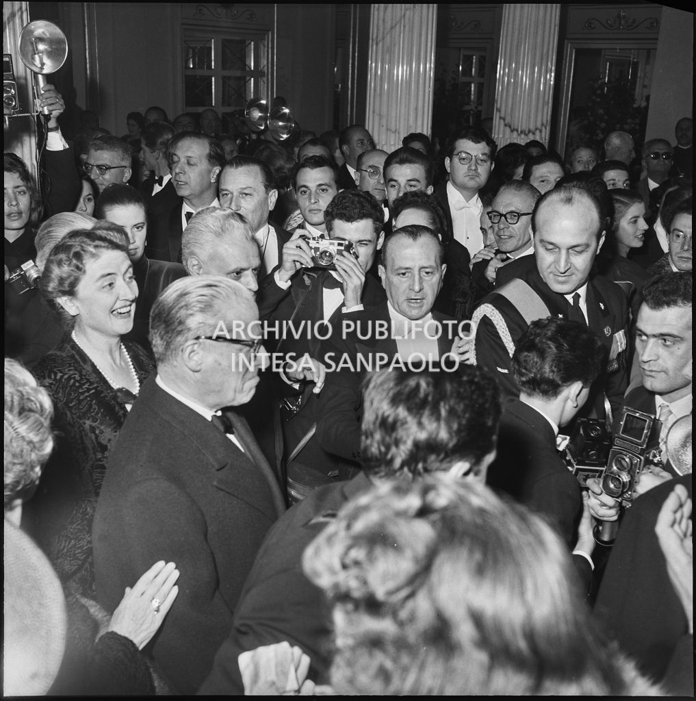 Il presidente della Repubblica Giovanni Gronchi e la moglie Carla Bissatini, tra gli altri, nel foyer del Teatro alla Scala, in occasione della serata inaugurale della stagione lirica 1955-1956 con l'opera "Norma" di Vincenzo Bellini, diretta da Antonino Votto, con la regia di Margherita Wallmann