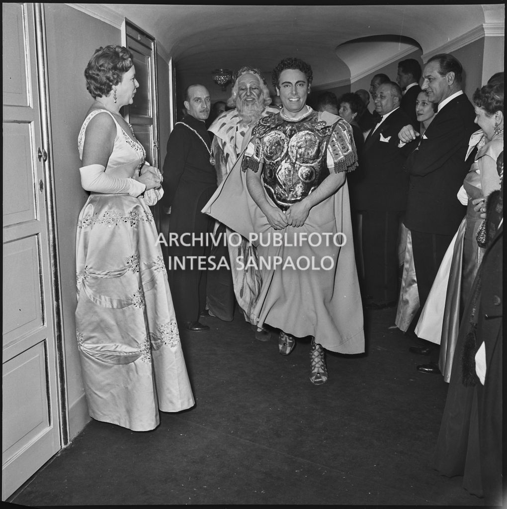 Il tenore Mario Del Monaco seguito dal basso Nicola Zaccaria, in costume di scena, tra il pubblico al Teatro alla Scala in occasione della serata inaugurale della stagione lirica 1955-1956 con l'opera "Norma" di Vincenzo Bellini, diretta da Antonino Votto, con la regia di Margherita Wallmann