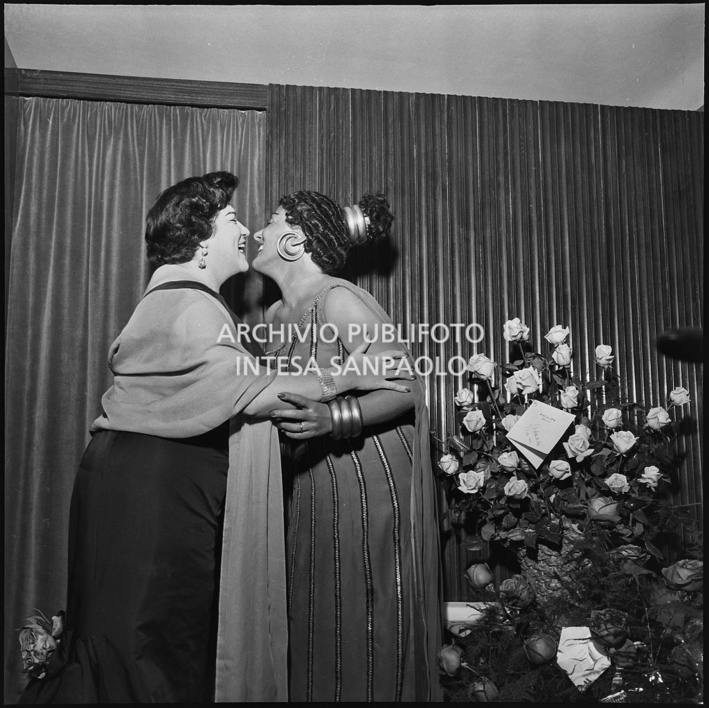 Il soprano Antonietta Stella, in costume di scena, in camerino con Emilia Carlini la sera dell'inaugurazione della stagione lirica 1956-1957 del Teatro alla Scala, con l'opera "Aida" di Giuseppe Verdi, diretta da Antonino Votto, con la regia di Franco Enriquez, nella quale intrepreta Amneris