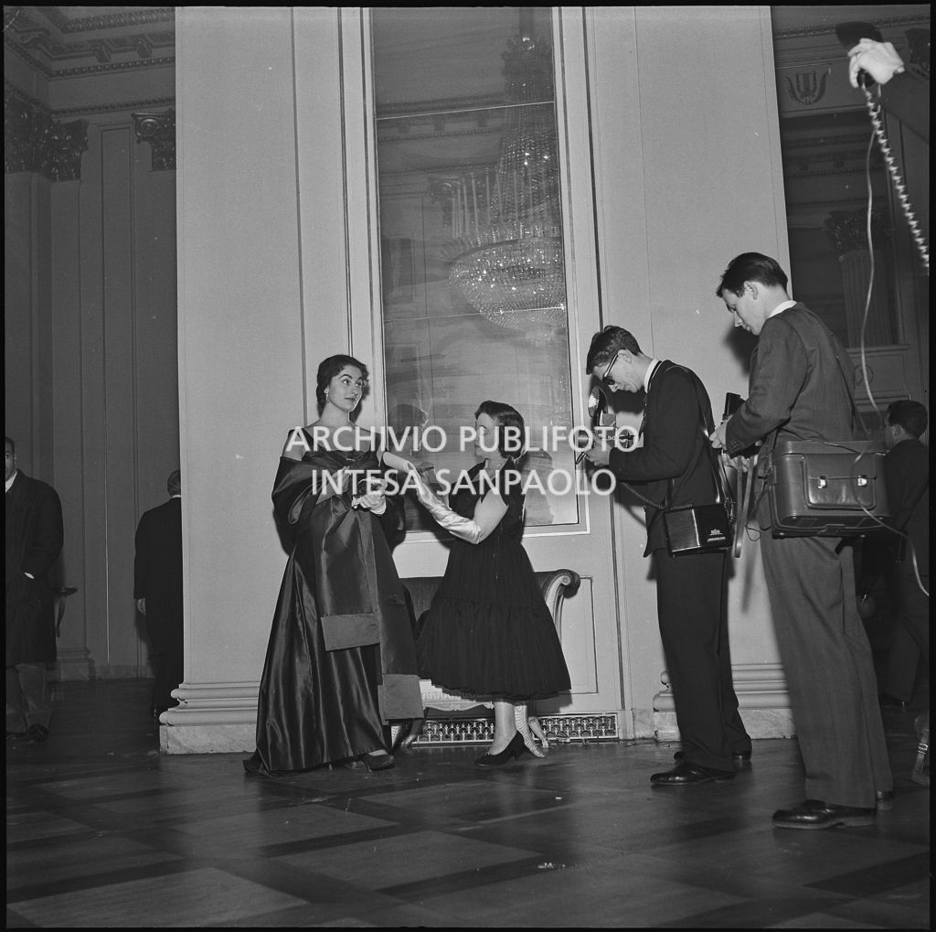 Eliana de Sabata, intervistata e fotografata al Teatro alla Scala, in occasione della serata inaugurale della stagione lirica 1956-1957 con l'opera "Aida" di Giuseppe Verdi, diretta da Antonino Votto, con la regia di Franco Enriquez