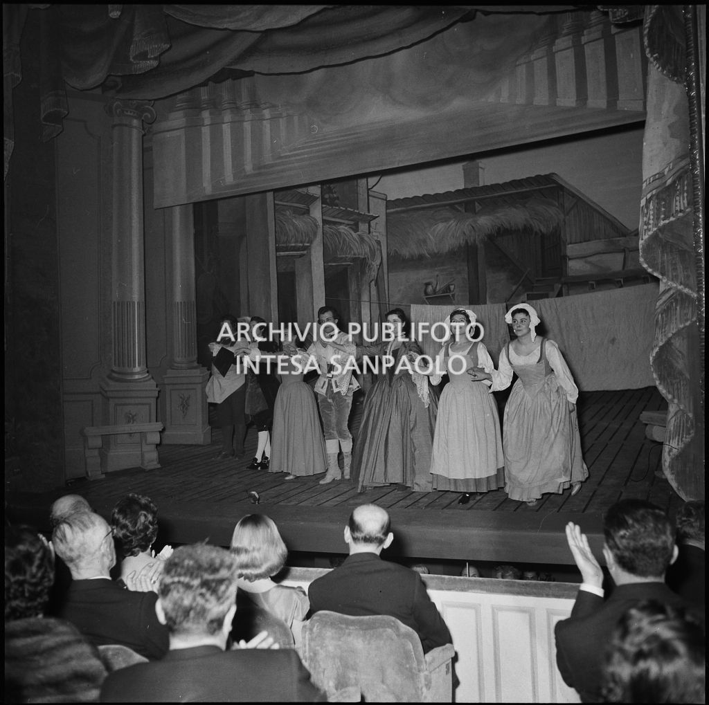 Gli artisti sul palcoscenico alla fine della rappresentazione dell'opera "La cecchina ossia la buona figliola" di Niccolò Vito Piccinni, diretta da Nino Sanzogno, con la regia di Franco Zeffirelli, con al quale si è inagurata la stagione lirica 1956-1957 della Piccola Scala