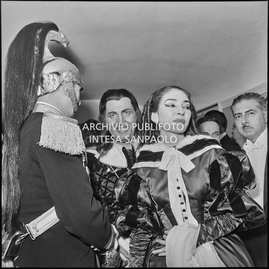 Il baritono Ettore Bastianini e la soprano Maria Callas in costume di scena, tra il pubblico, in occasione della serata inaugurale della stagione lirica 1957-1958 del Teatro alla Scala con l'opera di Giuseppe Verdi "Un ballo in maschera", diretta da Gianandrea Gavazzeni e con la regia di Margherita Wallmann
