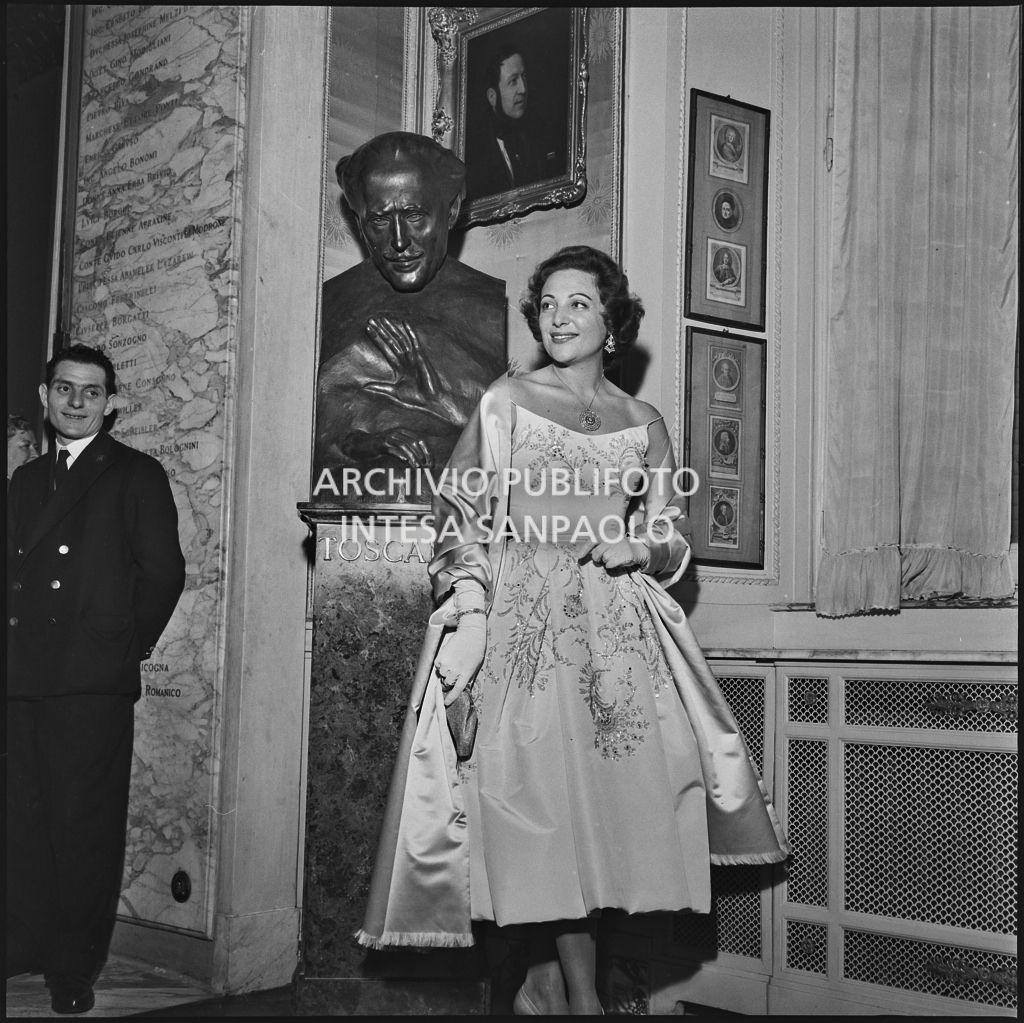 La ballerina Luciana Novaro ritratta davanti al busto di Arturo Toscanini  al Teatro alla Scala in occasione della serata inaugurale della stagione lirica 1957-1958 
				con l'opera di Giuseppe Verdi "Un ballo in maschera", diretta da Gianandrea Gavazzeni e con la regia di Margherita Wallmann
