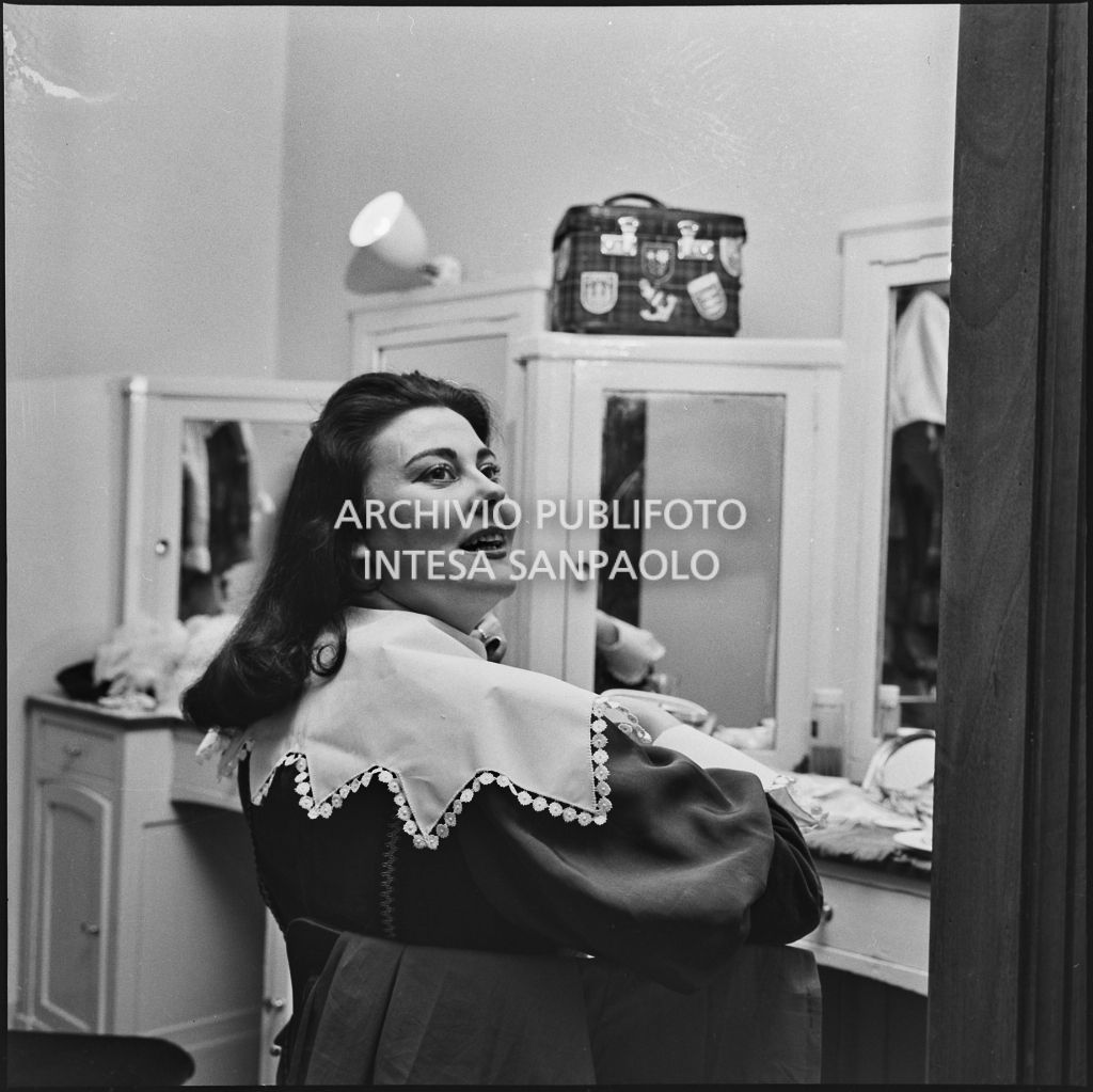 Il soprano Eugenia Ratti in camerino al Teatro alla Scala in occasione della serata inaugurale della stagione lirica 1957-1958 con l'opera di Giuseppe Verdi "Un ballo in maschera", diretta da Gianandrea Gavazzeni e con la regia di Margherita Wallmann