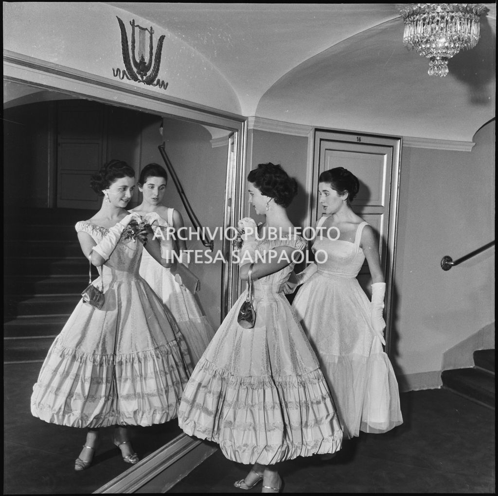 Stellina Magri e la sorella Antonia, nipoti di Antonio Ghiringhelli, davanti a uno specchio al Teatro alla Scala in occasione della serata inaugurale della stagione lirica 1957-1958 con l'opera di Giuseppe Verdi "Un ballo in maschera", diretta da Gianandrea Gavazzeni e con la regia di Margherita Wallmann