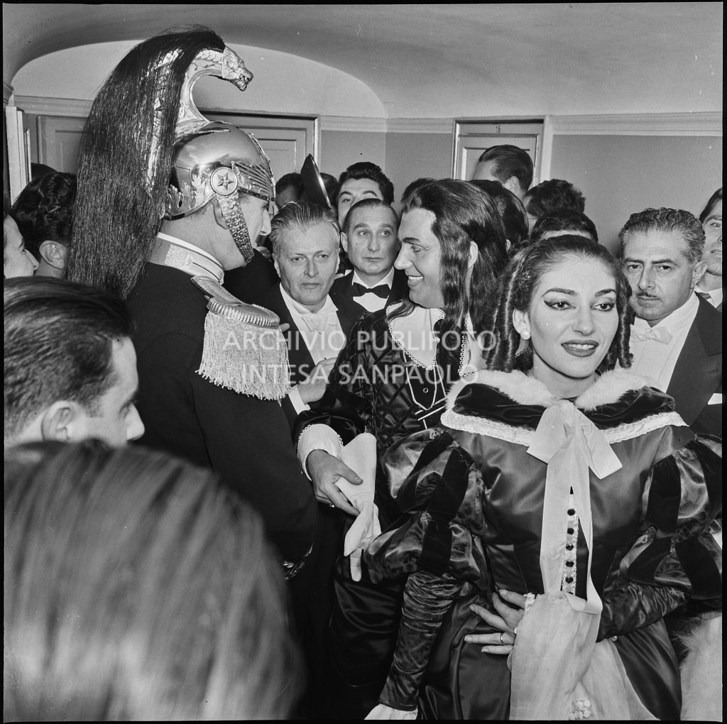 La soprano Maria Callas e il baritono Ettore Bastianini, in costume di scena, e il direttore d'orchestra Gianandrea Gavazzeni, tra il pubblico al Teatro alla Scala, in occasione della serata inaugurale della stagione lirica 1957-1958 con l'opera di Giuseppe Verdi "Un ballo in maschera", diretta dallo stesso Gavazzeni e con la regia di Margherita Wallmann