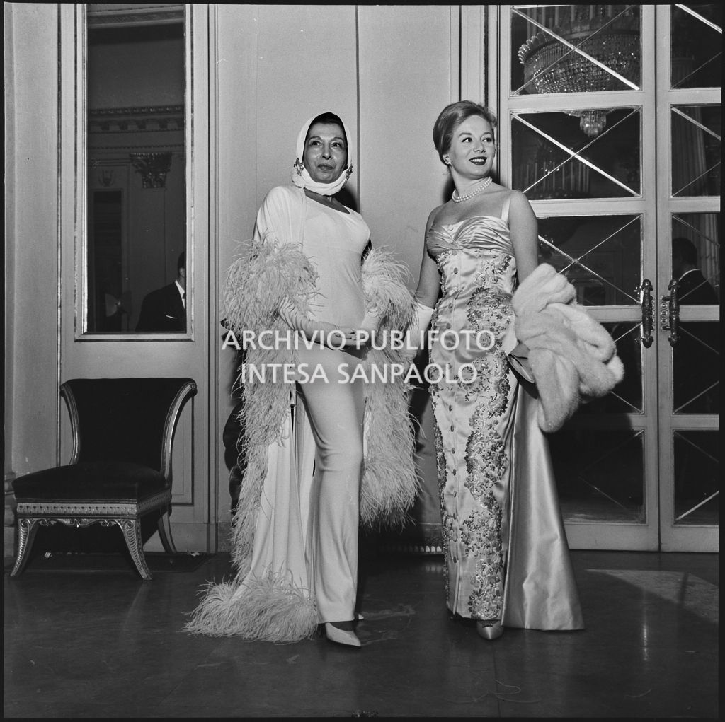Maria Pica e Gioia Lombroso nel foyer del Teatro alla Scala in occasione della serata inaugurale della stagione lirica 1957-1958 con l'opera di Giuseppe Verdi "Un ballo in maschera", diretta da Gianandrea Gavazzeni e con la regia di Margherita Wallmann
