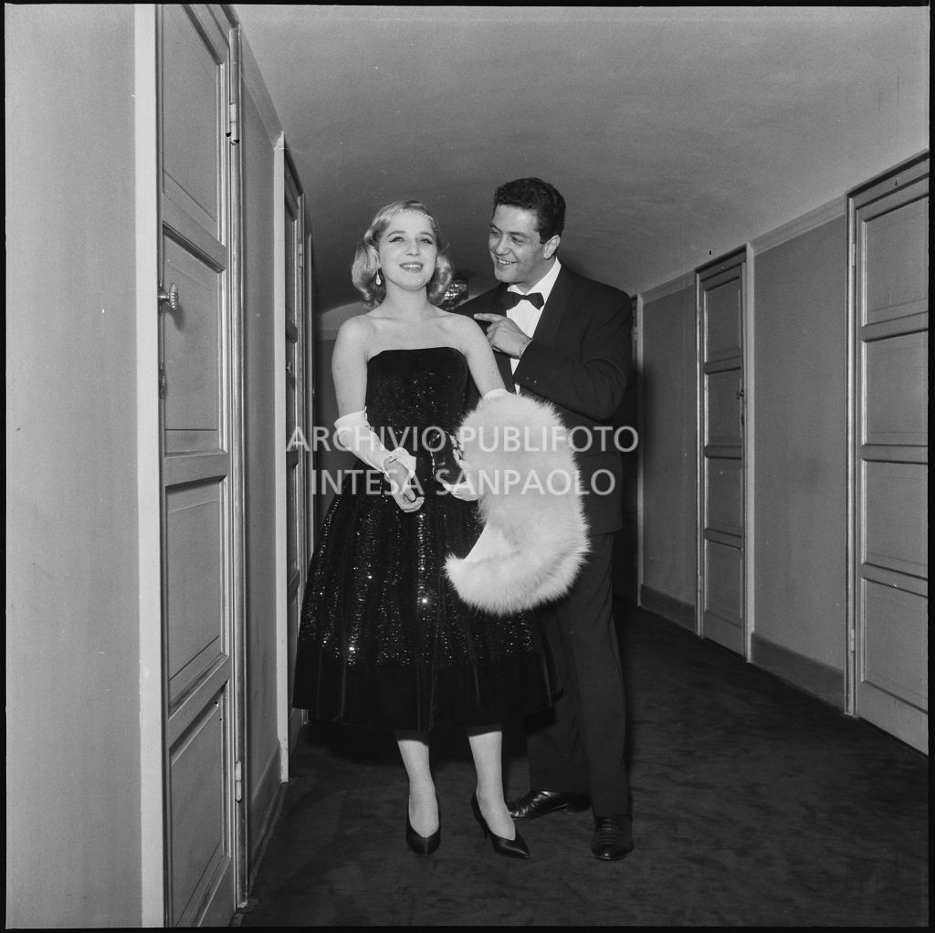 La contessina Carla Nani Mocenigo con il regista Franco Enriquez al Teatro alla Scala, in occasione della serata inaugurale della stagione lirica 1957-1958 con l'opera di Giuseppe Verdi "Un ballo in maschera", diretta da Gianandrea Gavazzeni e con la regia di Margherita Wallmann