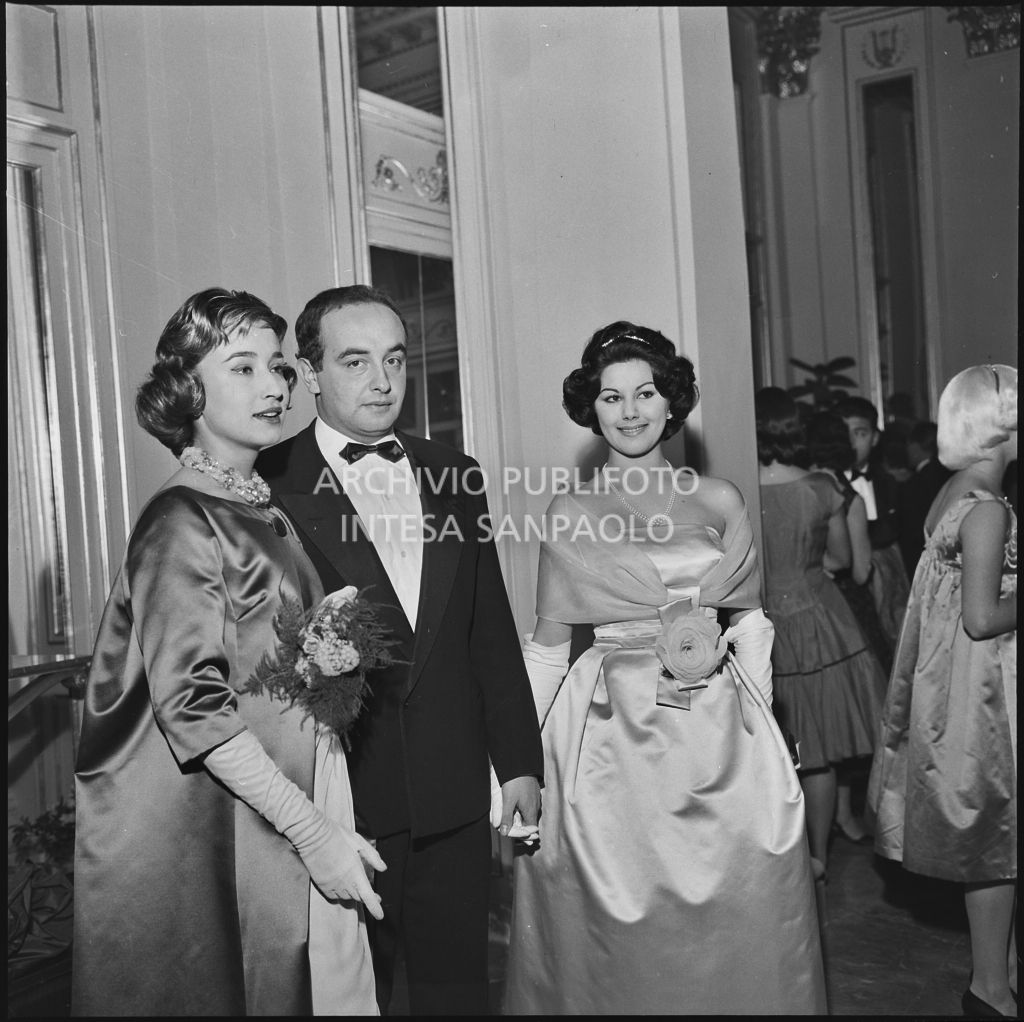 Giovanna Lomazzi e Maria Elisa Marzotto, con un altro spettatore, nel foyer del Teatro alla Scala in occasione della serata inaugurale della stagione lirica 1958-1959 con l'opera "Turandot" di Giacomo Puccini, diretta da Antonino Votto con la regia di Margherita Walmann