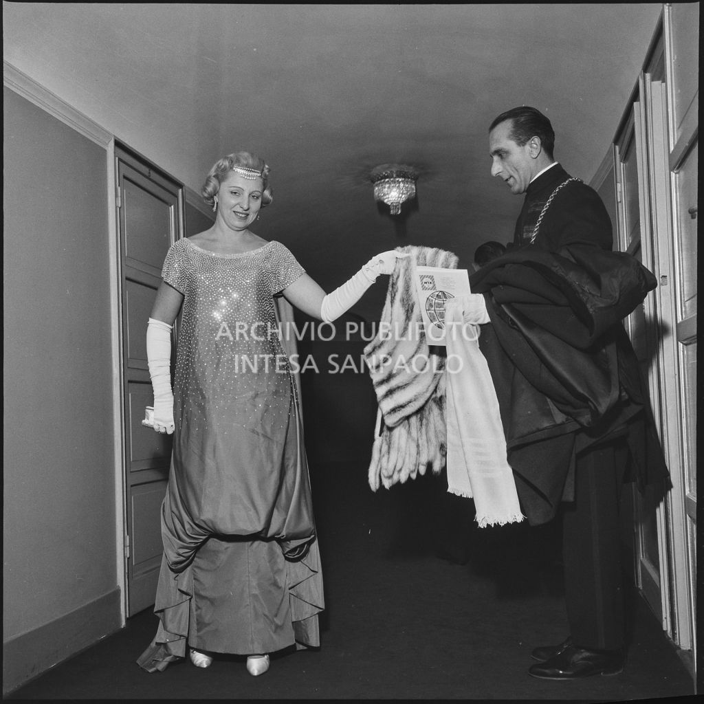Graziella Paolieri, assistita da una maschera, al Teatro alla Scala in occasione della serata inaugurale della stagione lirica 1958-1959 con l'opera "Turandot" di Giacomo Puccini, diretta da Antonino Votto con la regia di Margherita Walmann
