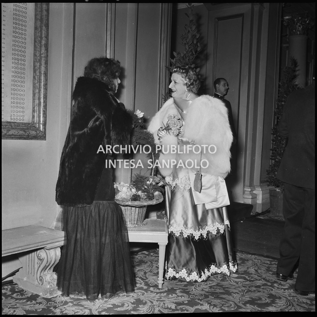 Tina Biffi con la fioraia del Teatro alla Scala in occasione della serata inaugurale della stagione lirica 1952-1953 con l'opera "Macbeth", di Giuseppe Verdi, diretta da Victor de Sabata, con la regia di Carl Ebert
