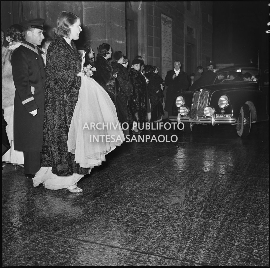 Spettatori all'esterno del Teatro alla Scala, nella galleria delle carrozze, la sera dell'inaugurazione della stagione lirica 1952-1953 con l'opera "Macbeth", di Giuseppe Verdi, diretta da Victor de Sabata, con la regia di Carl Ebert