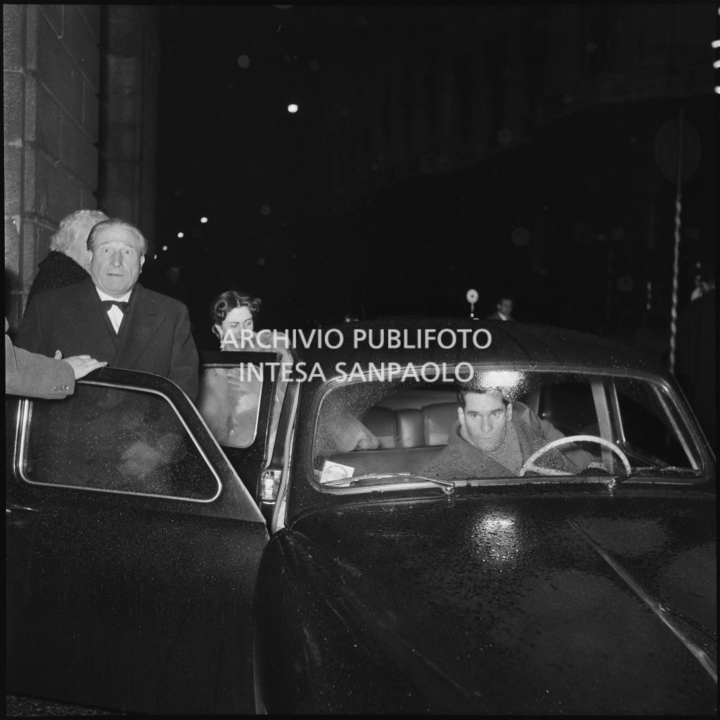 Il senatore Edoardo Origlia sale su un'automobile, nella galleria delle carrozze, fuori dal Teatro alla Scala, la sera dell'inaugurazione della stagione lirica 1952-1953 con l'opera "Macbeth", di Giuseppe Verdi, diretta da Victor de Sabata, con la regia di Carl Ebert