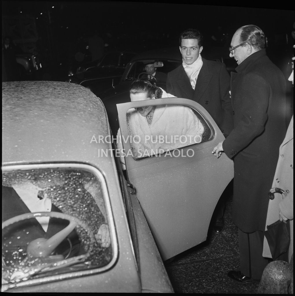 Spettatori salgono su un'automobile, nella galleria delle carrozze, fuori dal Teatro alla Scala, la sera dell'inaugurazione della stagione lirica 1952-1953 con l'opera "Macbeth", di Giuseppe Verdi, diretta da Victor de Sabata, con la regia di Carl Ebert