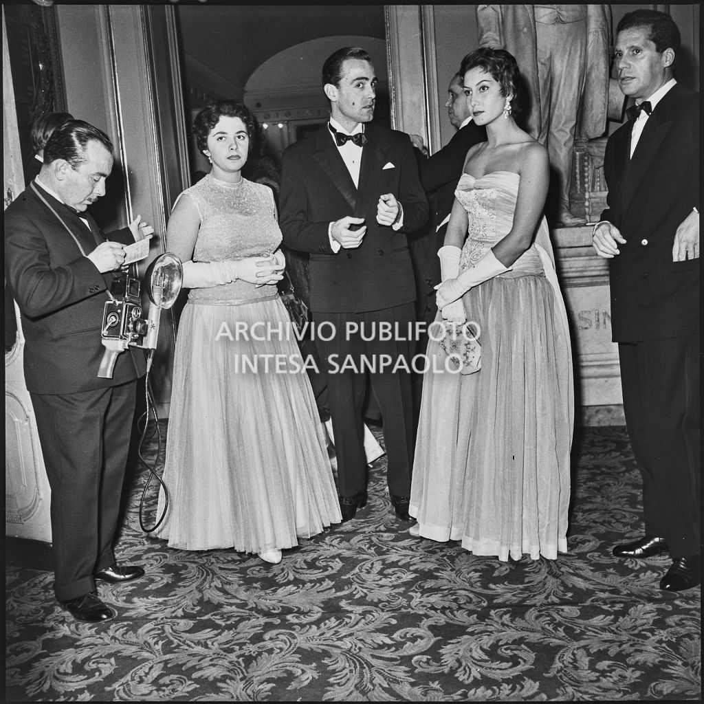 Da sinistra, il fotoreporter dell'agenzia Publifoto Franco Giglio, la signorina Rossi Cerri, un uomo non identificato, e Giuliana Brenner con il marito, al Teatro alla Scala in occasione della serata inaugurale della stagione lirica 1953-1954 con l'opera "La Wally", di Alfredo Catalani, diretta da Carlo Maria Giulini, con la regia di Tatiana Pavlova