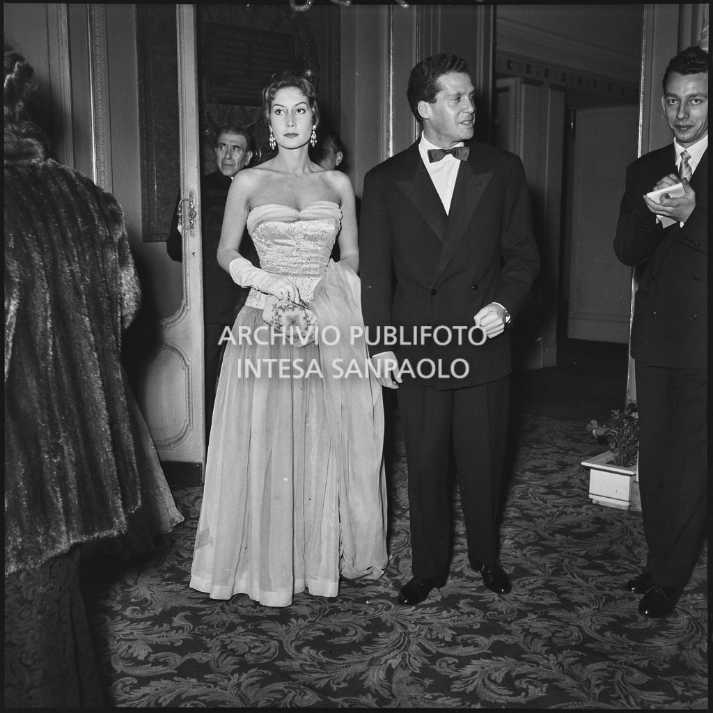 Giuliana Brenner con il marito nel foyer del Teatro alla Scala in occasione della serata inaugurale della stagione lirica 1953-1954 con l'opera "La Wally", di Alfredo Catalani, diretta da Carlo Maria Giulini, con la regia di Tatiana Pavlova