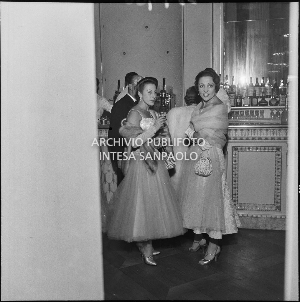 Luciana Novaro (a destra), prima ballerina del Teatro alla Scala, al bar del ridotto, la sera dell'inaugurazione della stagione lirica 1954-1955, con l'opera "La Vestale", di Gaspare Spontini, diretta da Antonino Votto, con la regia di Luchino Visconti