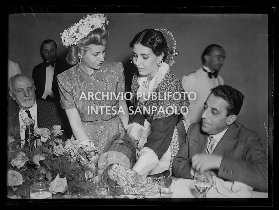 Evita Perón riceve un dono da una donna in abiti tradizionali durante un ricevimento in occasione della sua visita<br>31972