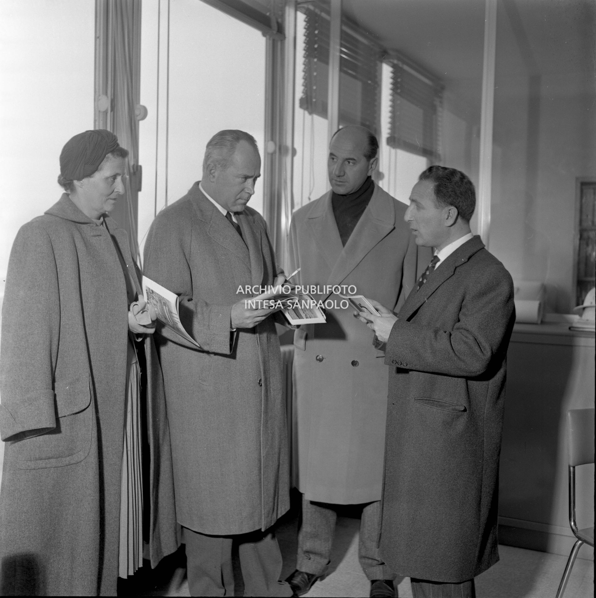 I visitatori osservano brochure in un ufficio dello stabilimento; il secondo da destra è Eugenio Cefis<br>441571