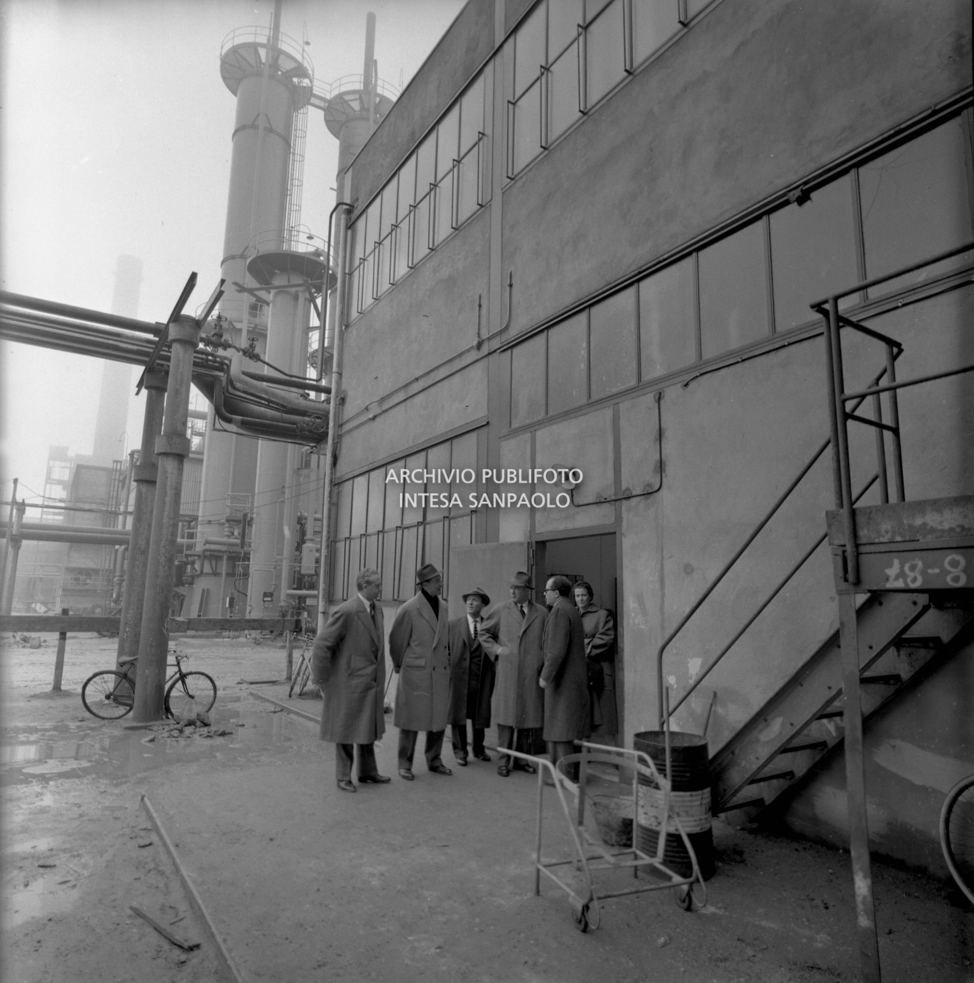 Eugenio Cefis, primo da sinistra, con i visitatori all'uscita di un edificio dello stabilimento<br>441572