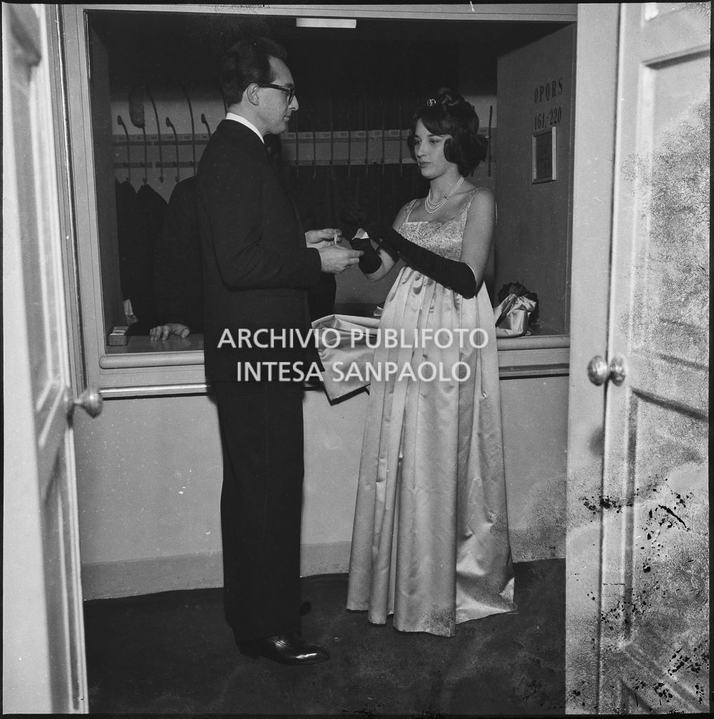Giuliana Olcese in compagnia di un uomo nel guardaroba del Teatro alla Scala in occasione della serata inaugurale della stagione lirica 1958-1959 con l'opera "Turandot", di Giacomo Puccini, diretta da Antonino Votto con la regia di Margherita Wallmann