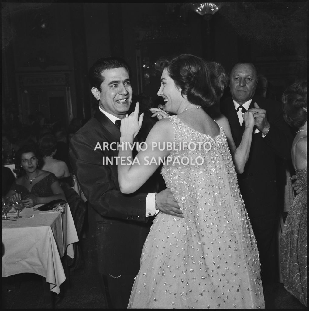 Il tenore Giuseppe Di Stefano danza con una donna al ristorante dopo la serata inaugurale della stagione lirica 1958-1959 del Teatro alla Scala con l'opera "Turandot", di Giacomo Puccini, diretta da Antonino Votto con la regia di Margherita Wallmann