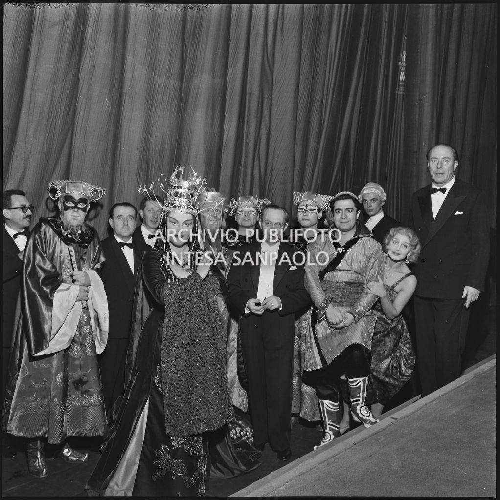 Gli artisti, in abiti di scena, il direttore d'orchestra Antonino Votto e la regista Margherita Wallmann dietro al sipario del Teatro alla Scala in occasione della serata inaugurale della stagione lirica 1958-1959 con l'opera "Turandot", di Giacomo Puccini, diretta da Antonino Votto con la regia di Margherita Wallmann
