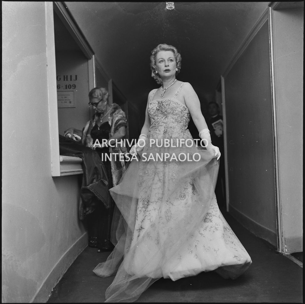 Rita Puccini, mentre mostra il proprio abito, al Teatro alla Scala in occasione della serata inaugurale della stagione lirica 1958-1959 con l'opera "Turandot", di Giacomo Puccini, diretta da Antonino Votto con la regia di Margherita Wallmann