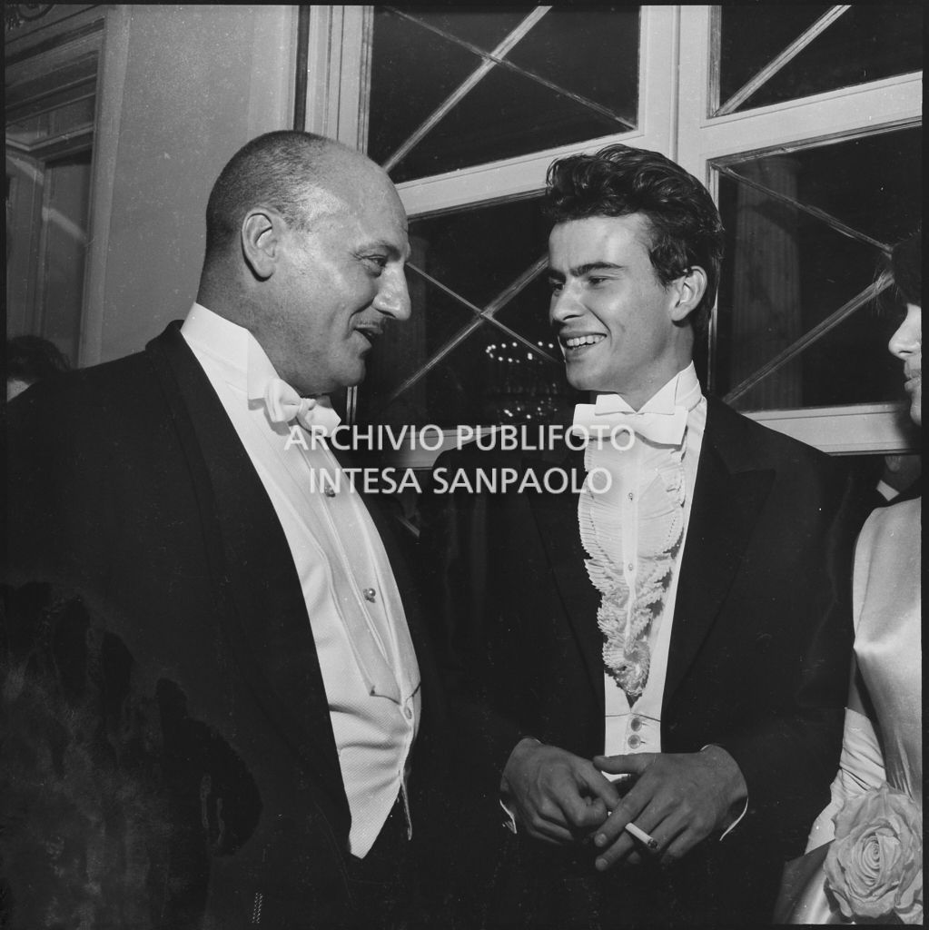 Lo stilista Pierre Balmain e l'attore Horst Buchholz al Teatro alla Scala in occasione della serata inaugurale della stagione lirica 1960-1961 con l'opera "Poliuto" di Gaetano Donizetti, diretta da Antonino Votto con la regia di Herbert Graf