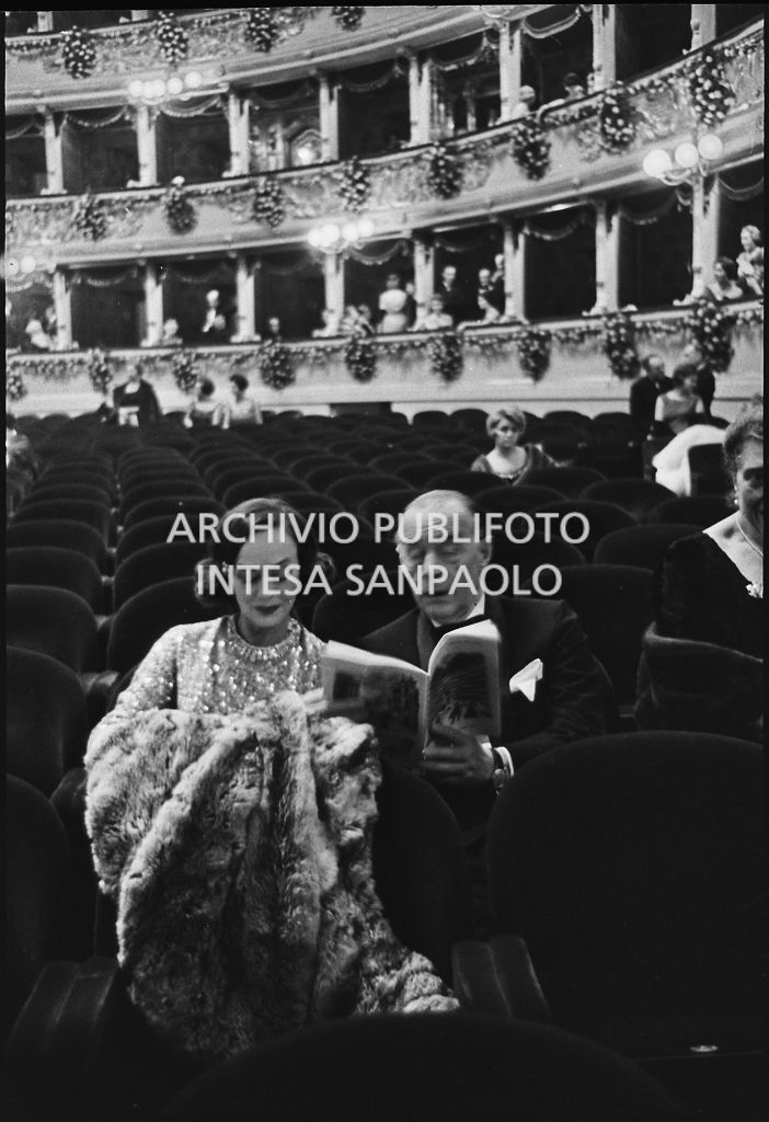 Erich Maria Remarque e Paulette Goddard seduti nella platea del Teatro alla Scala in occasione della serata inaugurale della stagione lirica 1960-1961 con l'opera "Poliuto" di Gaetano Donizetti, diretta da Antonino Votto con la regia di Herbert Graf