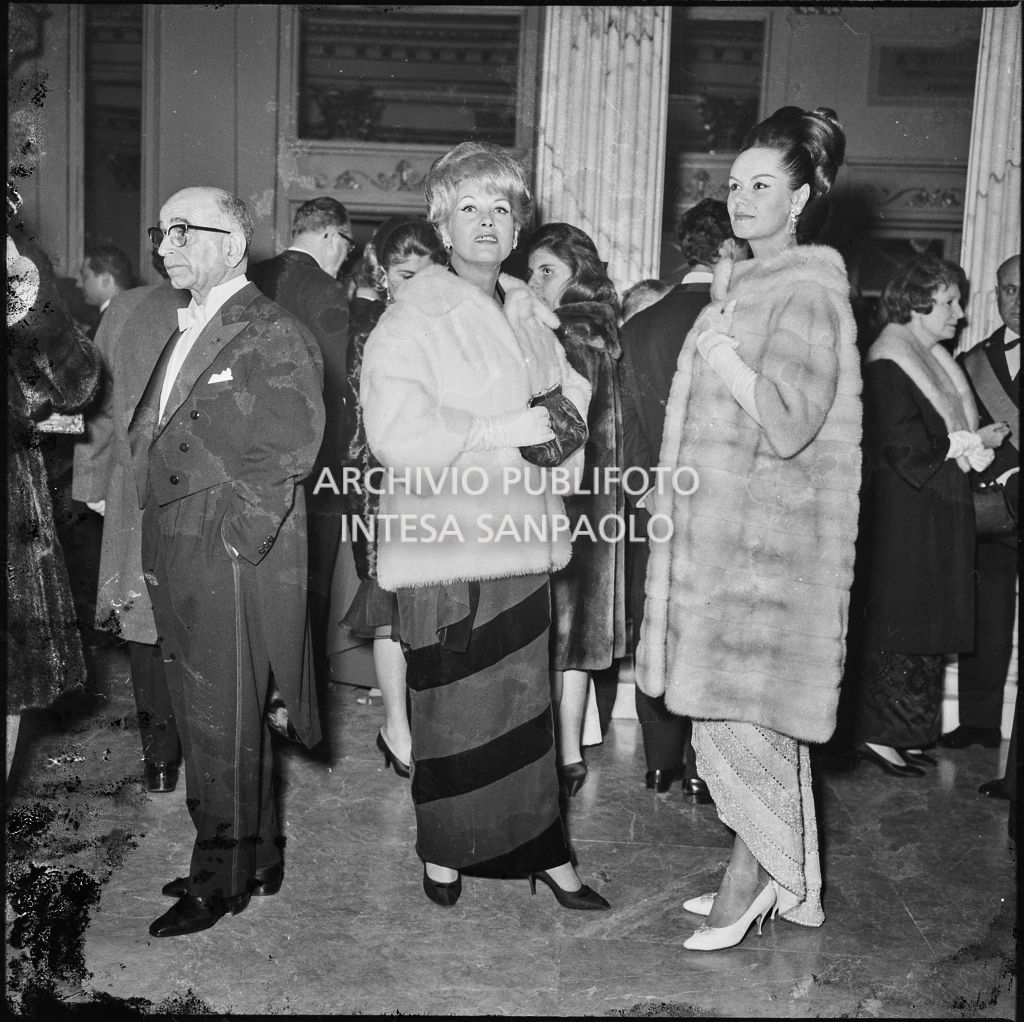 Mimi Alberini e Nuccia Bavera nel foyer del Teatro alla Scala in occasione della serata inaugurale della stagione lirica 1963-1964 con le opere "Cavalleria Rusticana" e "L'amico Fritz" di Pietro Mascagni, dirette da Gianandrea Gavazzeni e la regia di Franco Enriquez