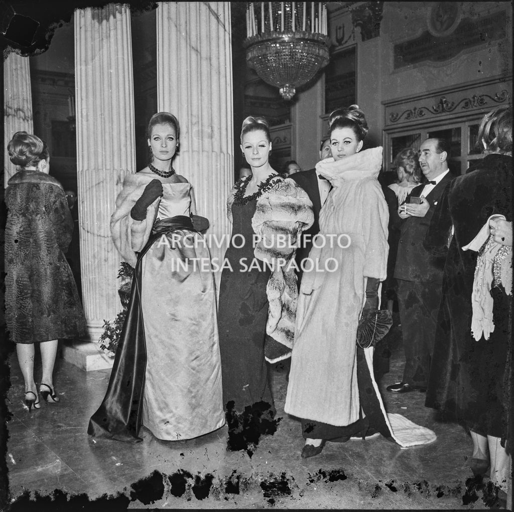 Isa Stoppi, Valmarin Leda e Gemma Alferazzi, modelle della sartoria Biki, nel foyer del Teatro alla Scala in occasione della serata inaugurale della stagione lirica 1963-1964 con le opere "Cavalleria Rusticana" e "L'amico Fritz" di Pietro Mascagni, dirette da Gianandrea Gavazzeni e la regia di Franco Enriquez