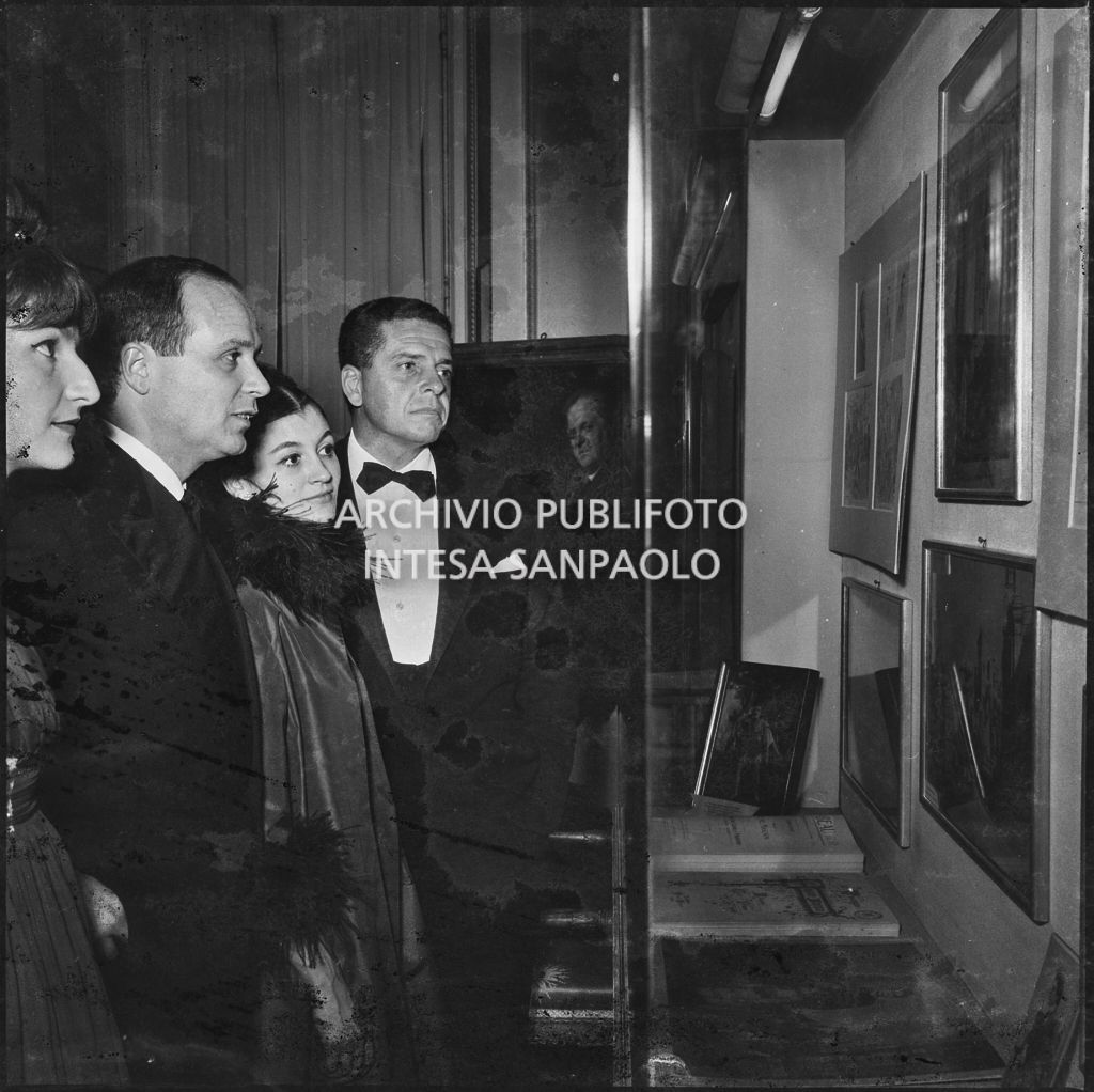 Carla Fracci e il marito Beppe Menegatti osservano una vetrina del museo del Teatro alla Scala in occasione della serata inaugurale della stagione lirica 1963-1964 con le opere "Cavalleria Rusticana" e "L'amico Fritz" di Pietro Mascagni, dirette da Gianandrea Gavazzeni e la regia di Franco Enriquez