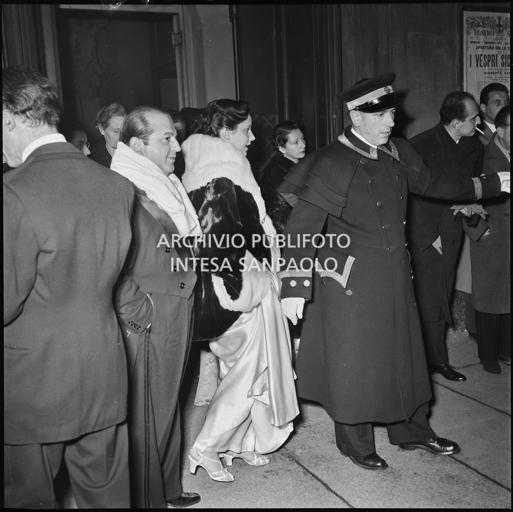 Spettatori in attesa delle automobili nella galleria delle carrozze del Teatro alla Scala al termine della serata inaugurale della stagione lirica 1951-1952, aperta con l'opera "I vespri siciliani" di Giuseppe Verdi, diretta da Victor de Sabata, con la regia di Herbert Graf