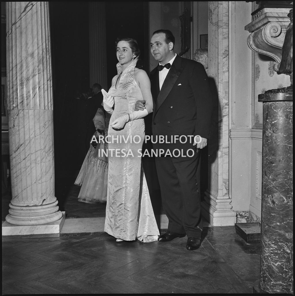 La signora Cauli in compagnia di un uomo nel foyer del Teatro alla Scala in occasione della serata inaugurale della stagione lirica 1952-1953 con l'opera "Macbeth" di Giuseppe Verdi diretta da Victor de Sabata, con la regia di Carl Ebert