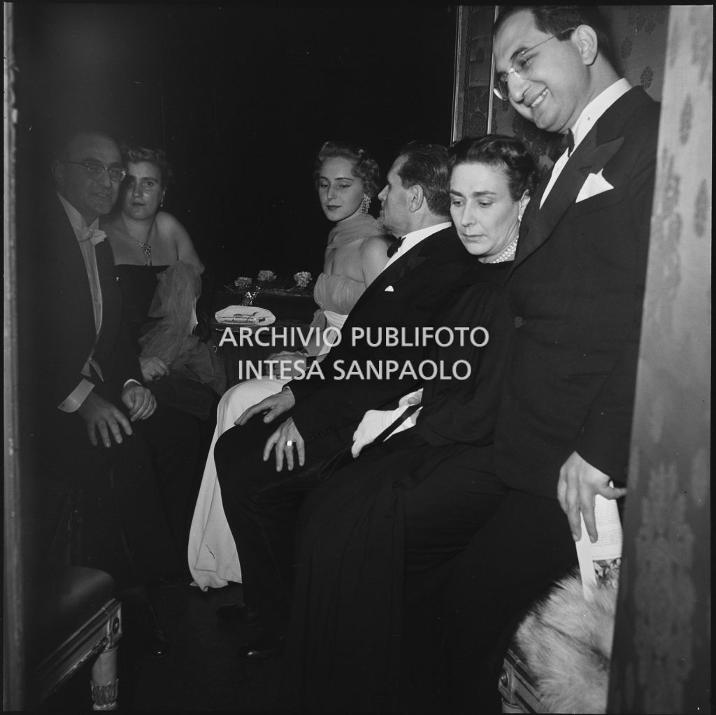Teodoro Bubbio seduto tra Wally Toscanini e Emanuela di Castelbarco Toscanini, con altri spettatori, in un palco del Teatro alla Scala in occasione della serata inaugurale della stagione lirica 1953-1954 con l'opera "La Wally", di Alfredo Catalani, diretta da Carlo Maria Giulini, con la regia di Tatiana Pavlova