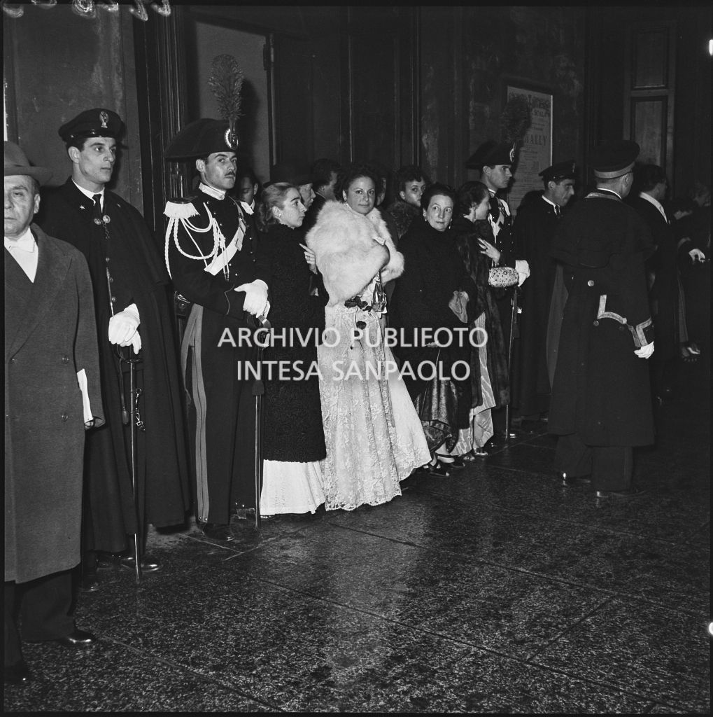 Alcuni spettatori nella galleria delle carrozze del Teatro alla Scala, in attesa delle automobili, al termine della serata inaugurale della stagione lirica 1953-1954 con l'opera "La Wally", di Alfredo Catalani, diretta da Carlo Maria Giulini, con la regia di Tatiana Pavlova