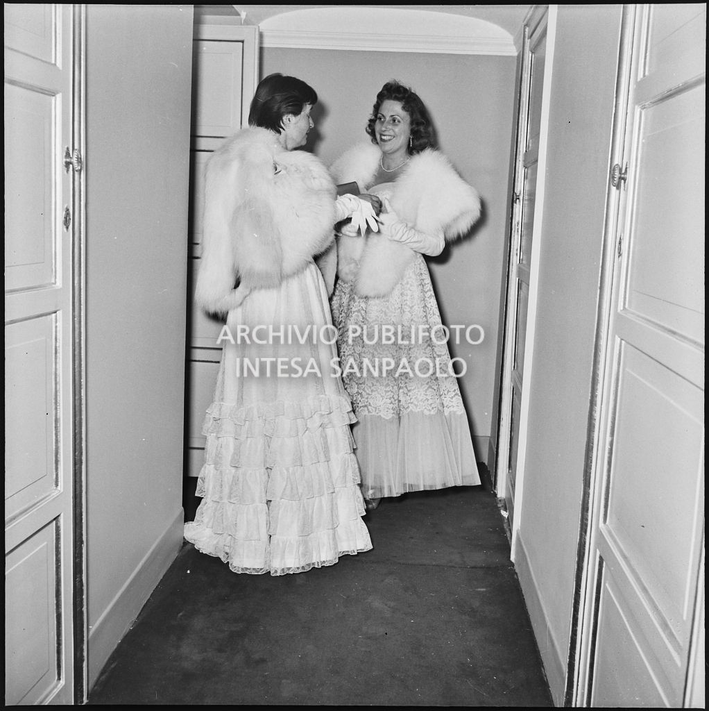 Due spettatrici al Teatro alla Scala in occasione della serata inaugurale della stagione lirica 1955-1956 con l'opera "Norma" di Vincenzo Bellini, diretta da Antonino Votto, con la regia di Margherita Wallmann