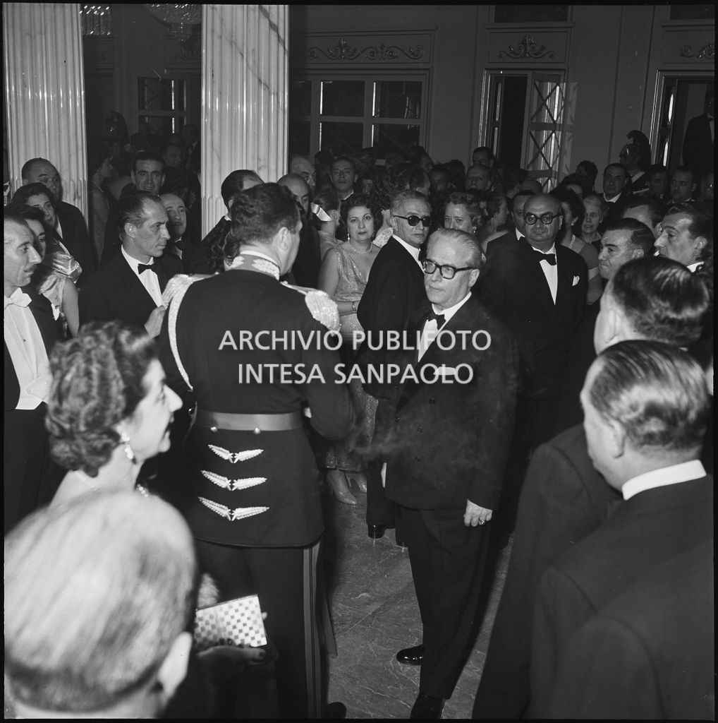 Il presidente della Repubblica Giovanni Gronchi nel foyer del Teatro alla Scala, gremito di persone, in occasione della serata inaugurale della stagione lirica 1955-1956 con l'opera "Norma" di Vincenzo Bellini, diretta da Antonino Votto, con la regia di Margherita Wallmann